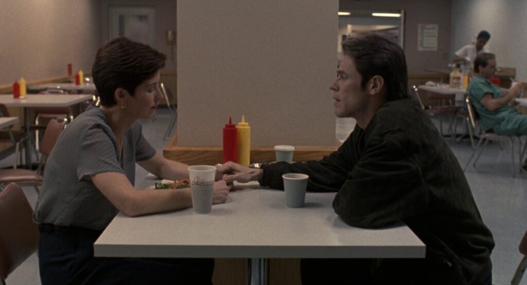 Sixth shot of the sequence. We are back to the initial medium shot of John and Marianne at the table.